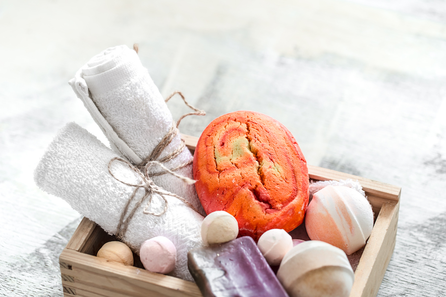 Beauty care products in wooden box. soap, towel with orange bath bomb. Spa or personal hygiene concept